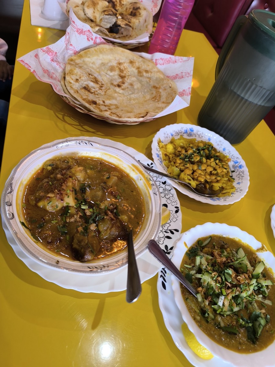 A deshi spread at Moon Coffee & Restaurant — paratha, paya, chana and a fresh salad