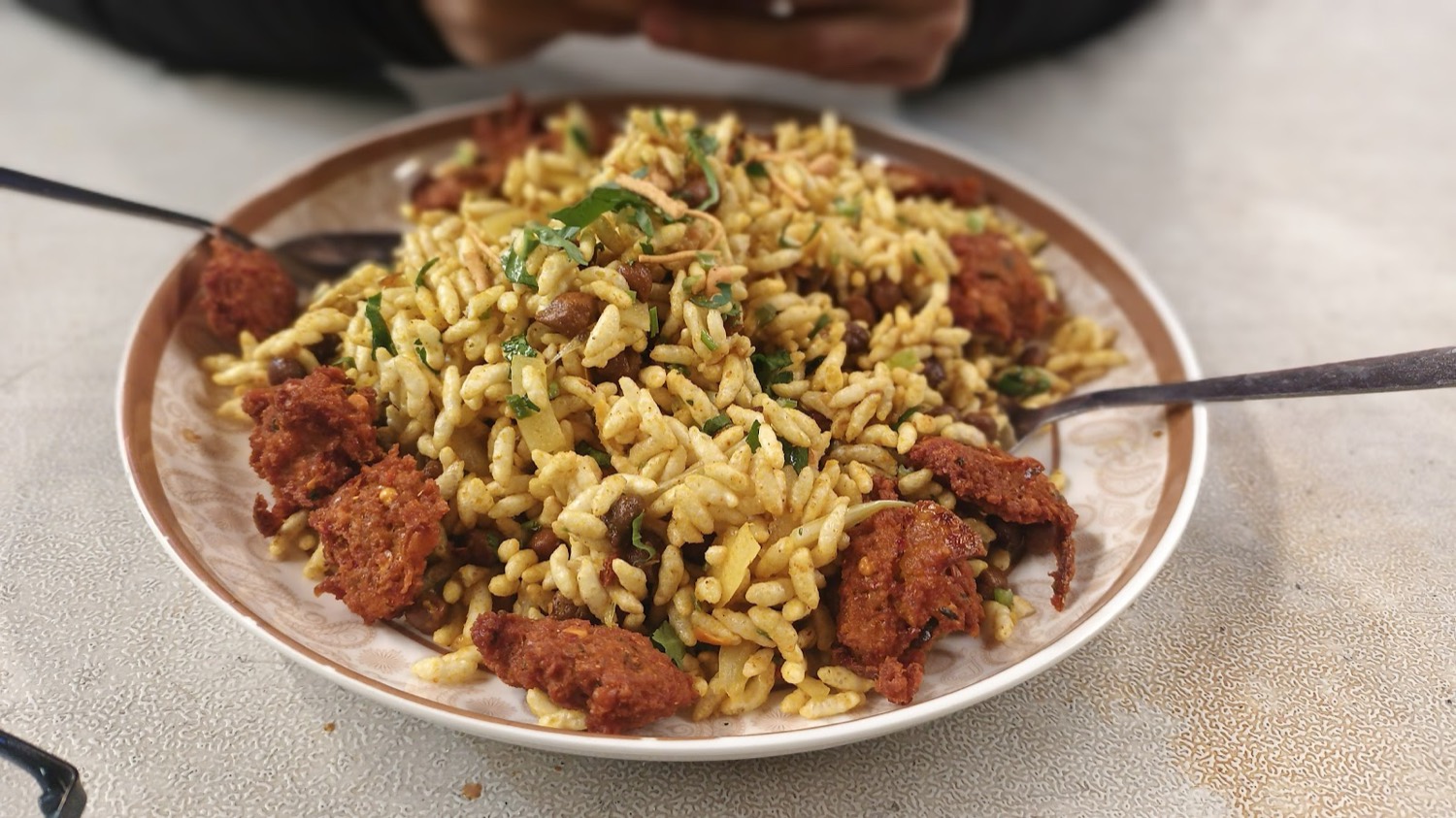 A plate of jhalmuri, puffed rice tossed with spices and fritters